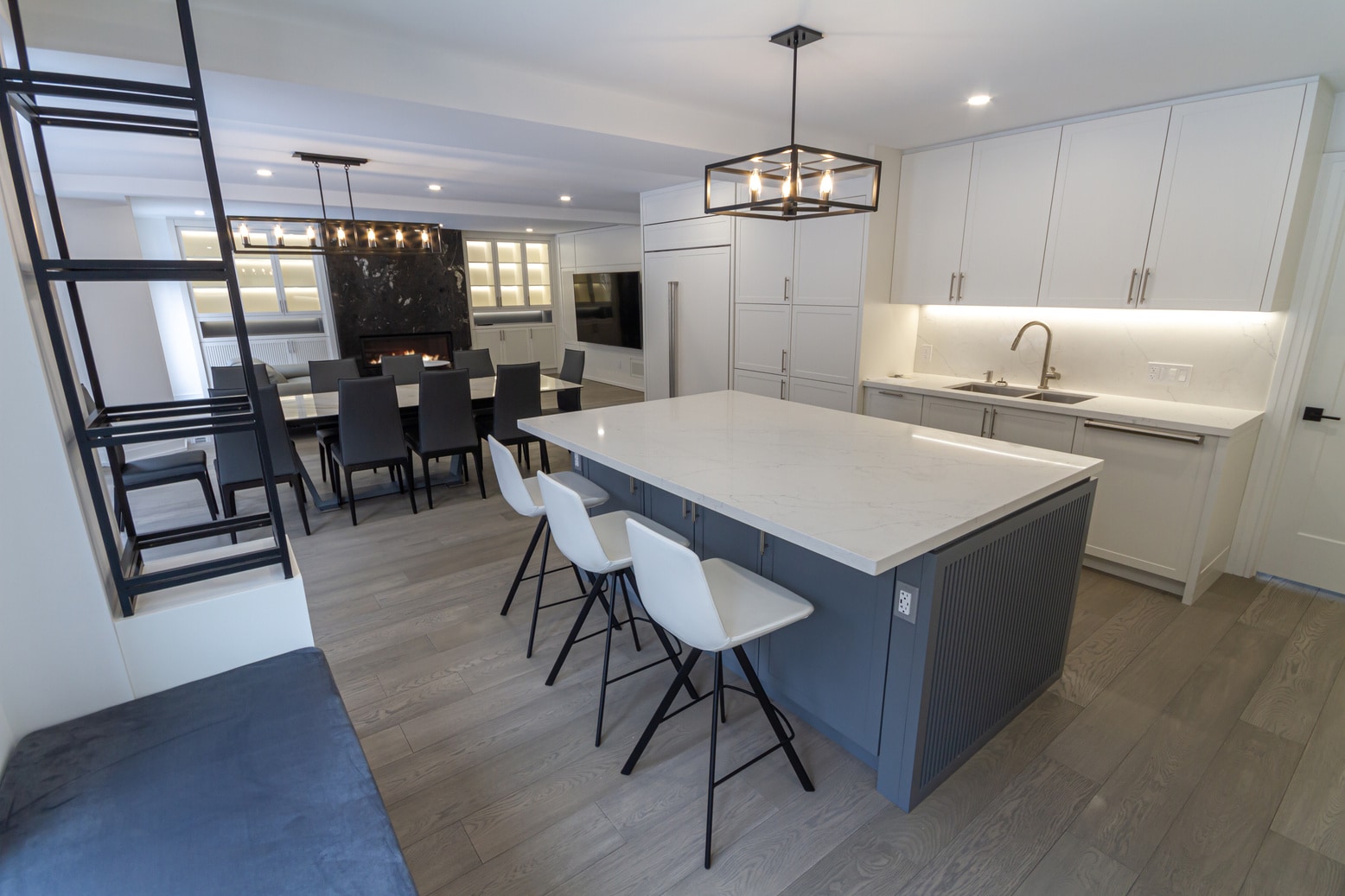 Open-concept Wilfred Court kitchen with a grey island, custom cabinetry, and integrated lighting