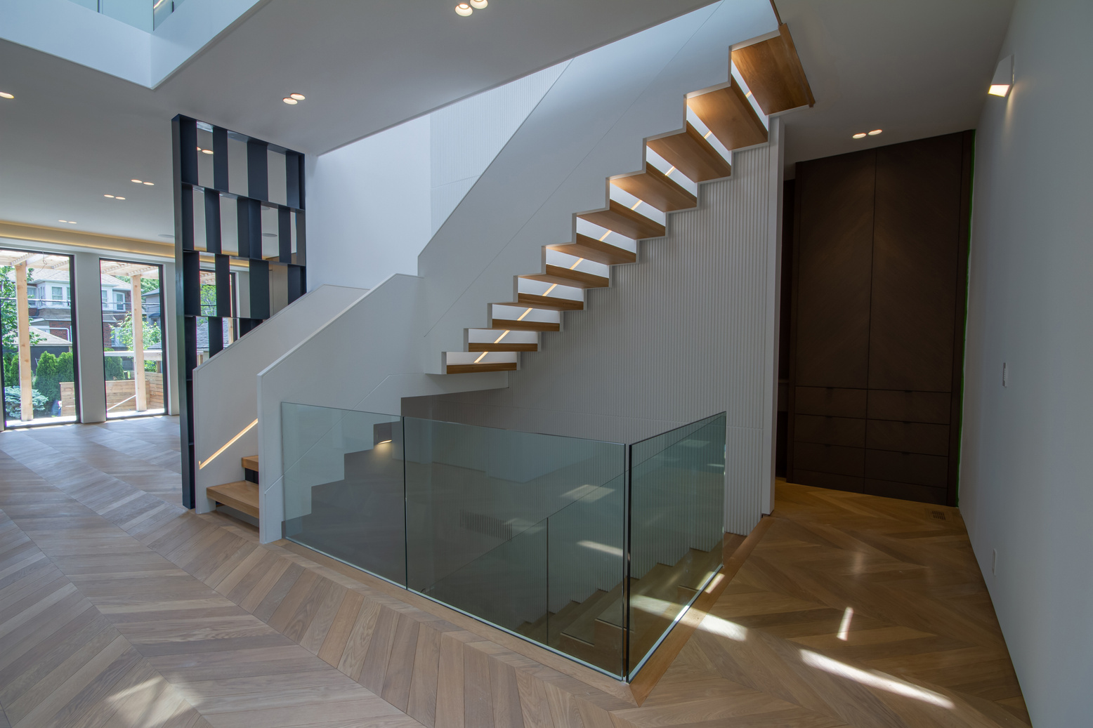 Light-filled White Spruce interior with a sculptural floating oak staircase