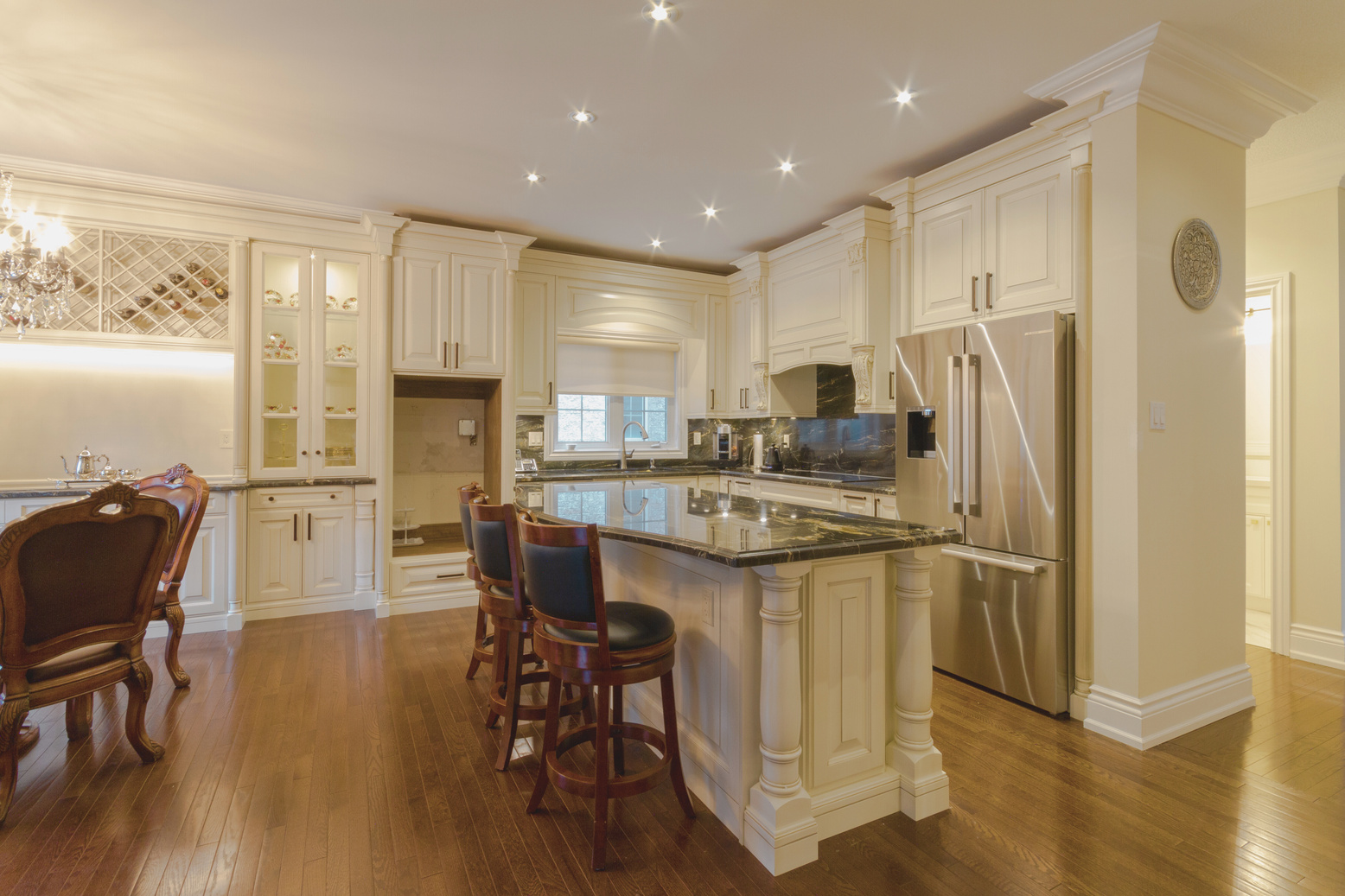 Finished Queen Filomena Residence kitchen with light cabinetry and a stone island